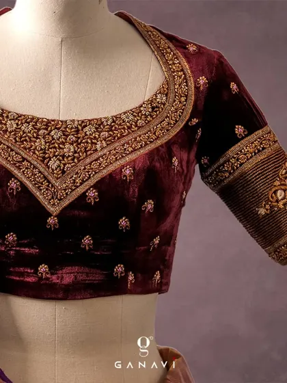 A close-up of the maroon velvet blouse, highlighting the intricate zardozi work along the neckline. The design features elephant motifs on the sleeves, a nod to traditional Indian symbolism and artistry.