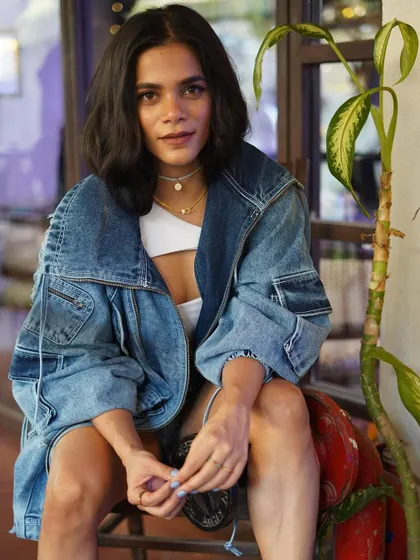 A relaxed pose that shows off the full street style vibe. The oversized jacket, shorts, and sneakers are a perfect urban uniform.