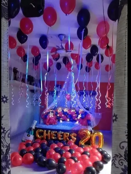 A full view of the 'Cheers to 20' room decoration. You can see the balloons hanging from the ceiling with ribbons, the decorated bed, and the balloon-filled floor.