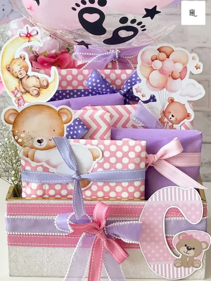 A personalized hamper to welcome baby Gaia. This gift features her initial 'G' and is filled with beautifully wrapped essentials in a lovely pink and purple teddy bear theme.