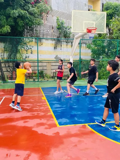 A young player practices shooting form on the wet court.