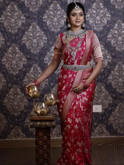 This silver-finish AD diamond set offers a sophisticated and modern bridal or reception look. The intricate design of the necklace and matching belt (vaddanam) pairs beautifully with this floral pink saree.