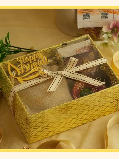 A yellow-themed gift box with a transparent lid and a "Happy Diwali" cutout, perfect for showcasing the goodies inside.