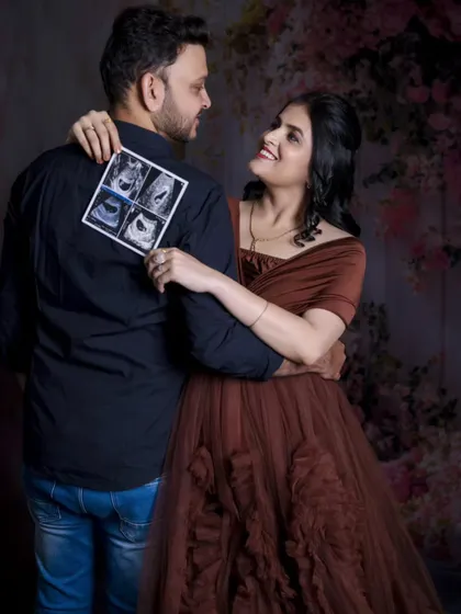 A creative and sweet shot where the mom-to-be shows her partner the ultrasound photos. It’s a beautiful way to capture the reality of the new life they've created.