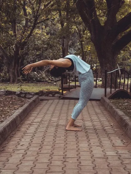 A standing backbend on an outdoor path. As the great B.K.S. Iyengar said, in backbends, the outer mind is silenced and the inner mind is made to work. They teach us to be "cautiously bold."