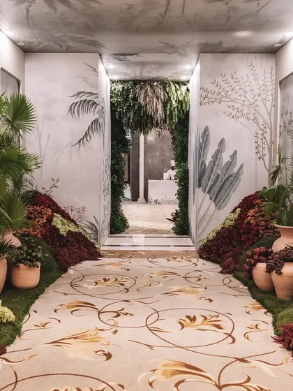 The entrance corridor to the 'Orchard of Life' naming ceremony, lined with earthen pots and floral arrangements.