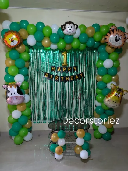 A direct shot of the jungle animal balloon arch, perfect for cake cutting photos. The '1 Happy Birthday' banner clearly marks the special first milestone.