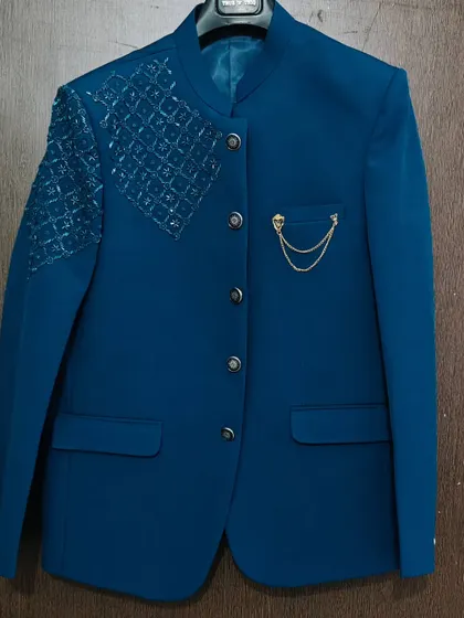 This royal blue Jodhpuri-style blazer with shoulder detailing is a modern and stylish option. It's a great rental piece for grooms or for a fashionable pre-wedding look.