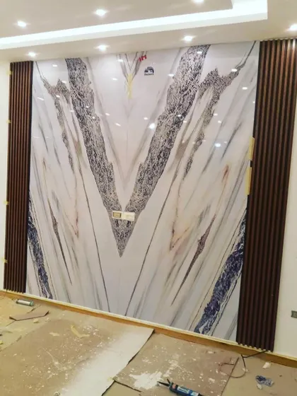 This stunning wall features a large, book-matched marble-style PVC panel. Framed by dark wood fluting, it creates a bold and luxurious statement, perfect for a high-end living room or reception area.