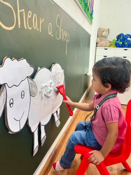 This little farmer is focused on the task of shearing the sheep. Activities like this connect to our "Farm Week" theme, making learning about animals a hands-on experience.