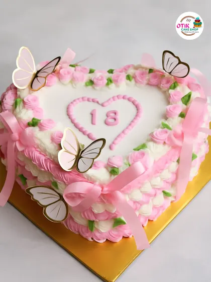 This heart-shaped cake is perfect for celebrating a milestone like an 18th birthday. The vintage-style piping, pink ribbons, and fluttering butterflies create a sweet and nostalgic feel.