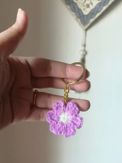A lovely lavender floral keychain with a white center.
