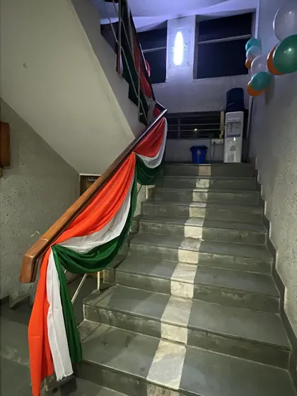 I make sure no corner is left undecorated. Here, the staircase railing is elegantly wrapped in tricolor fabric for a continuous festive theme.