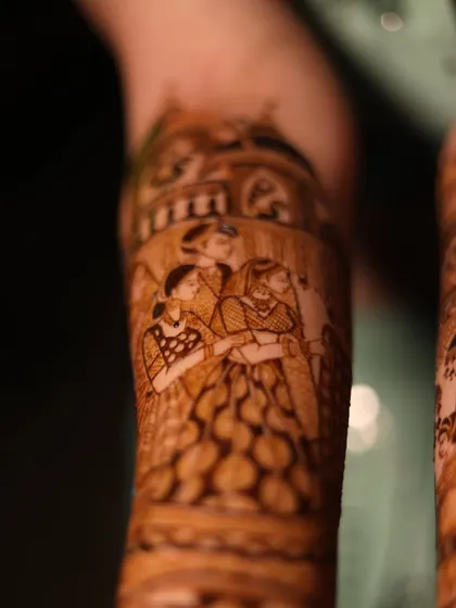 A close-up of a family portrait within a bridal mehandi. Including loved ones in the design makes it even more special.