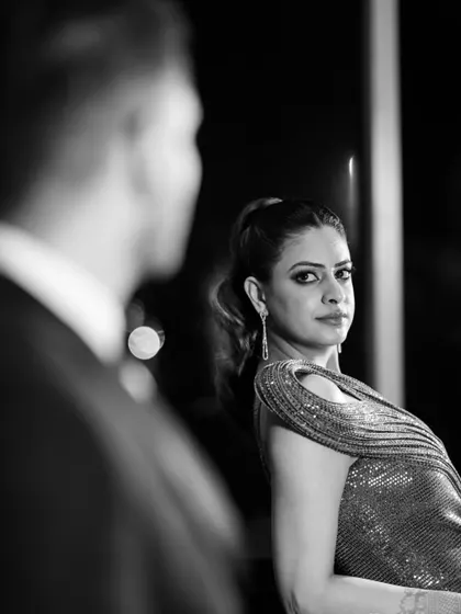 A powerful, moody portrait from a cocktail night. The bride gives an intense look over her shoulder, captured in stunning black and white.