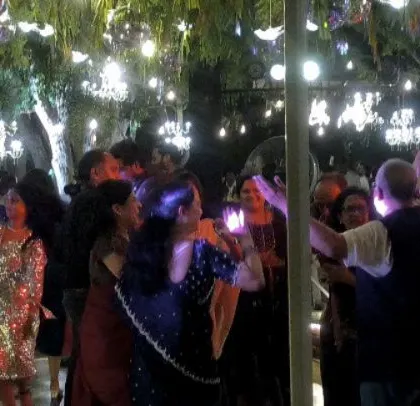 Guests dancing under the beautiful outdoor lighting.