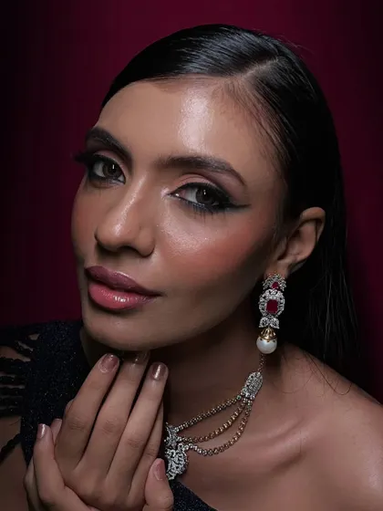 This is my signature red carpet glam. The focus is on creating luminous skin, a sharp, graphic eyeliner, and perfectly blended eyeshadow to complement the model's features and the luxurious jewelry. This look is designed to be striking both in person and in high-definition photography.