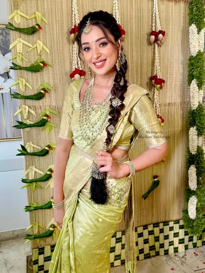 A happy bride ready for her Vratham ceremony. The makeup is fresh and bright, with a focus on glowing skin and a joyful smile, perfectly matching the festive decor.