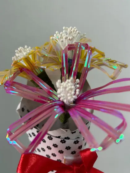 A close-up of the iridescent wire ribbon flowers. The students learned to fold and shape the ribbons to create these delicate, shimmering petals.
