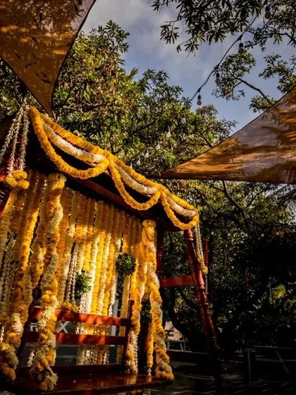 A beautifully decorated wooden swing, adorned with yellow marigolds, waiting for the couple. It's a symbol of joy and togetherness.