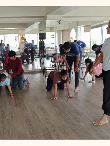 Partners learn practical techniques to provide physical support during labor. Here, they practice a position to relieve back pressure, fostering a sense of teamwork and shared responsibility.