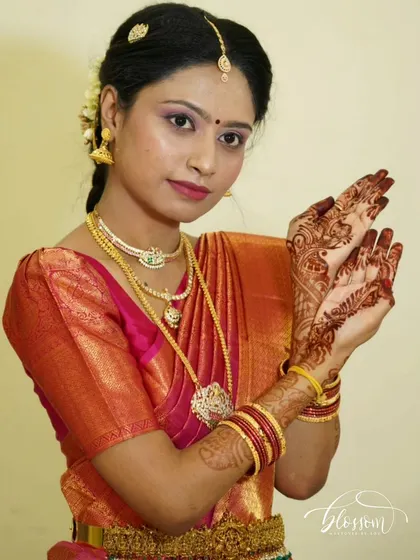 A simple and elegant engagement look. The focus here is on clean lines and a perfect fit, allowing the bride's natural beauty and her intricate henna to shine.