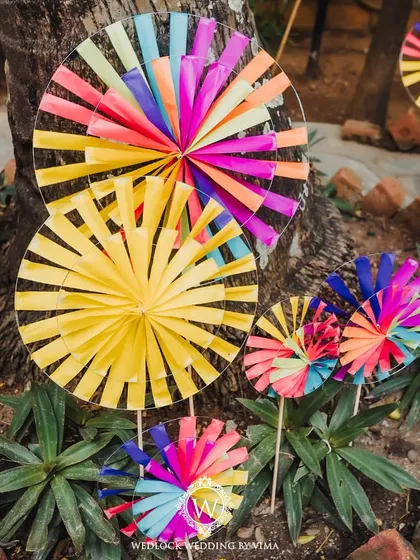 A pathway lined with colorful, handcrafted pinwheels and kites for a carnival-themed Mehendi. These playful details created a whimsical entrance for guests.
