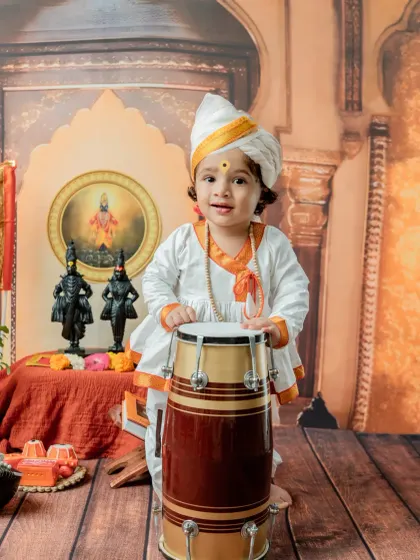 This little Varkari stands proudly with his dhol (drum). This shot is great for toddlers who are stable on their feet, capturing their playful energy and the spirit of the pilgrimage.
