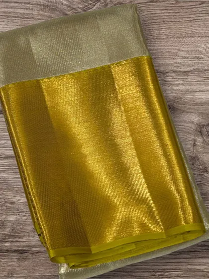 A pure Kanchi silk saree with a silver tissue body and a bright yellow-gold border.