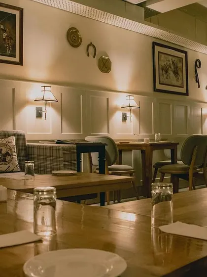 The decor of the Polo Lounge is carefully curated to evoke a sense of heritage and sport. Framed art, wall-mounted horseshoes, and classic wall paneling contribute to the timeless, sophisticated feel of the space.