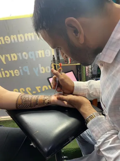A close-up of me teaching a student how to apply mehandi. Correct posture and cone-holding technique are the first steps to becoming a pro.