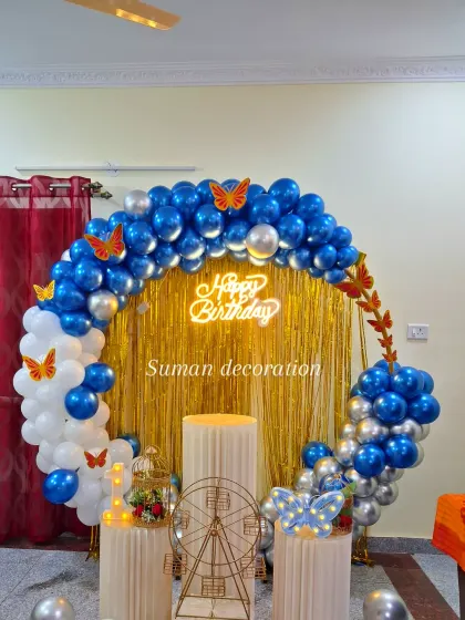 A clear view of the butterfly balloon ring with the 'Happy Birthday' neon sign glowing against the gold shimmer backdrop.