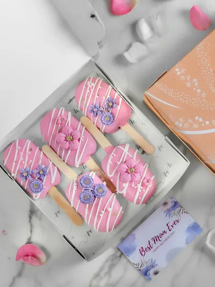 My Sweet Serendipity Cakesicles, created for Mother's Day. These pink cakesicles are decorated with white chocolate drizzles and delicate, handmade sugar flowers.