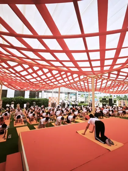 Leading a large group through a coordinated yoga flow. These events are a great way to foster a sense of community and shared purpose within a company.