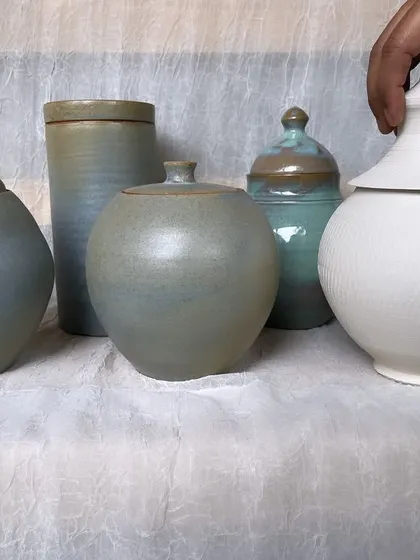 A collection of lidded jars from an intermediary course, showcasing different shapes, lid styles, and glaze finishes. Lidded forms are a great challenge for developing pottery skills.