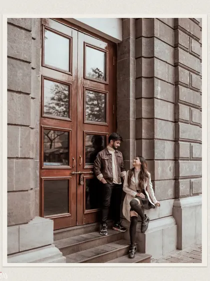 An editorial-style shot of the couple against a grand architectural door, highlighting their outfits and connection.
