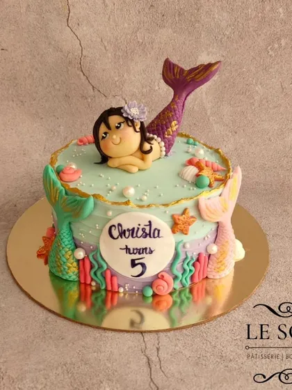 This magical mermaid cake was for Christa's 5th birthday. The 1 kg Vanilla Caramel cake is decorated with a beautiful hand-sculpted mermaid figurine, colorful tails, and seashell details.