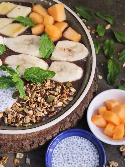 A beautiful overhead shot of our fruit smoothie bowl. Topped with banana, melon, chia pudding, and granola, it's a daily ritual of pure goodness that I have enjoyed for over 8 years.
