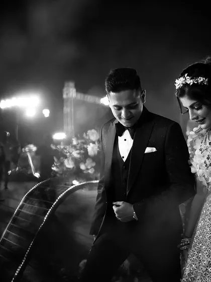A candid black and white photo of the couple making their entrance at the reception. The focus is on their shared moment as they step into the celebration together.