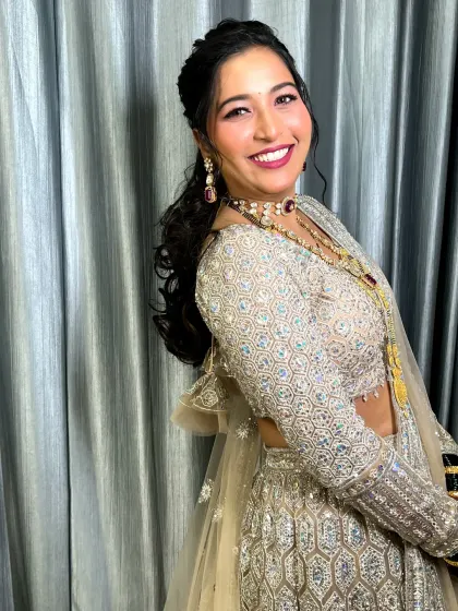 A side profile showing the elegant hairstyle and the beautiful smile of the bride in her reception attire.