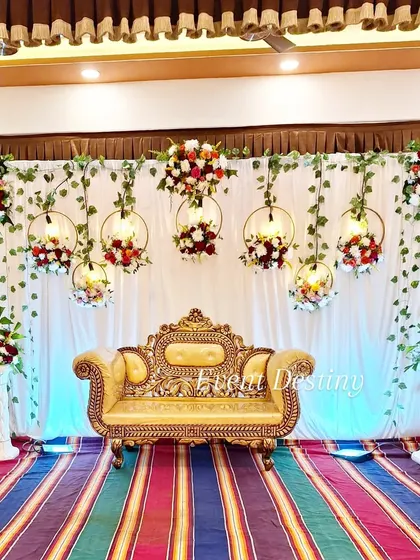 Another take on our popular hanging floral ring design, this time with vibrant red and white flowers. This setup was for a party hall with a colorful striped carpet, and we tailored the decor to complement the venue's existing look.