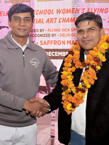 Shaking hands with a senior official at a martial arts championship.