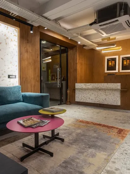 The lounge and reception area at SIRCA HQ, featuring a mix of textures like terrazzo flooring and wood paneling. The colorful furniture adds a playful touch to the corporate space.