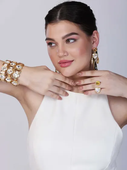 Another angle of the model showcasing the contemporary jewellery set, this time highlighting a large cocktail ring alongside the bracelet and earrings.