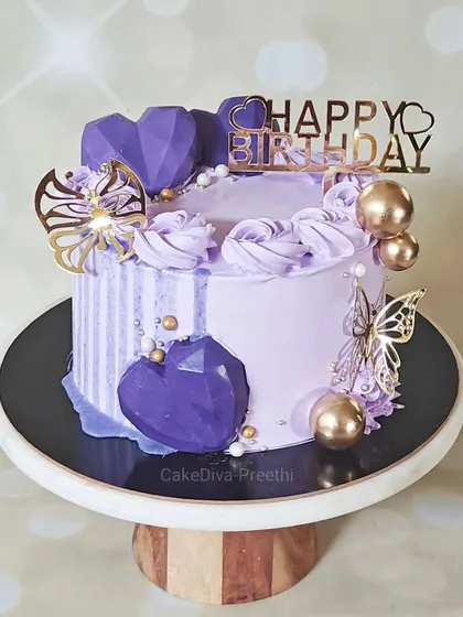 A beautiful lavender-themed cake featuring geometric chocolate hearts, gold butterflies, and a striped buttercream section. This design shows how I combine different modern elements into one cohesive piece.