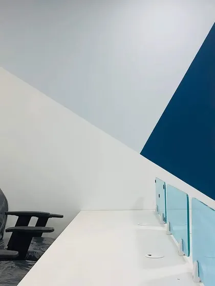 The completed office space, showing the geometric color-blocked wall design. This simple but effective feature adds a strong graphic element to the workspace.