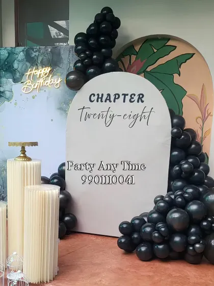 A close-up view of the custom arch panel and black balloon garland.