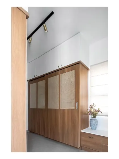 The spacious walk-in closet in the guest room, finished with teak laminate and rattan for a light and simple feel. This was carved out from a portion of the massive room.