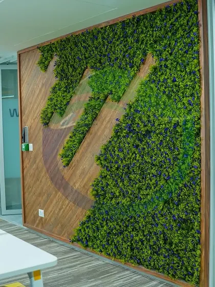 Here is a custom-framed moss wall featuring a logo cutout, blending wood and preserved moss. This is a great example of how we can integrate a company's brand directly into a biophilic art piece for a unique and memorable feature.