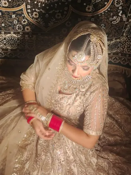 This bride is wearing a beautiful golden lehenga with a custom Polki choker and a traditional passa on the side, creating a classic Muslim bridal look.